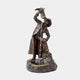 Large Traditional Drinking Cowboy Bronze Sculpture by Giant Sculptures, pouring water from a boot into his mouth, mounted on a rocky basin against plain background.