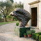 Large Traditional Eagle Head Bronze Bust by Giant Sculptures, 150cm dark patina profile with gold beak on a green marble plinth at a villa entrance.