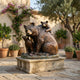 Large Traditional Mother Bear and Cubs Bronze Sculpture by Giant Sculptures on a stone plinth in a Mediterranean courtyard with olive trees and lavender.
