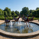 Large Traditional Running Deer Herd Bronze Fountain by Giant Sculptures with antique patina stags and does mid-leap in a stone pool with water jets.