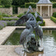 Large Traditional Three Herons Bronze Fountain by Giant Sculptures with verdigris patina, displayed beside a rectangular reflecting pool in a formal garden.