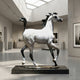 Large Traditional Walking Arabian Horse Bronze Sculpture by Giant Sculptures, white with black mane and tail, on a dark granite base in a gallery setting.
