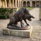 Large Traditional Wild Boar Bronze Sculpture by Giant Sculptures, 150cm, shown in side view with bared tusks on a stone plinth in a columned courtyard.