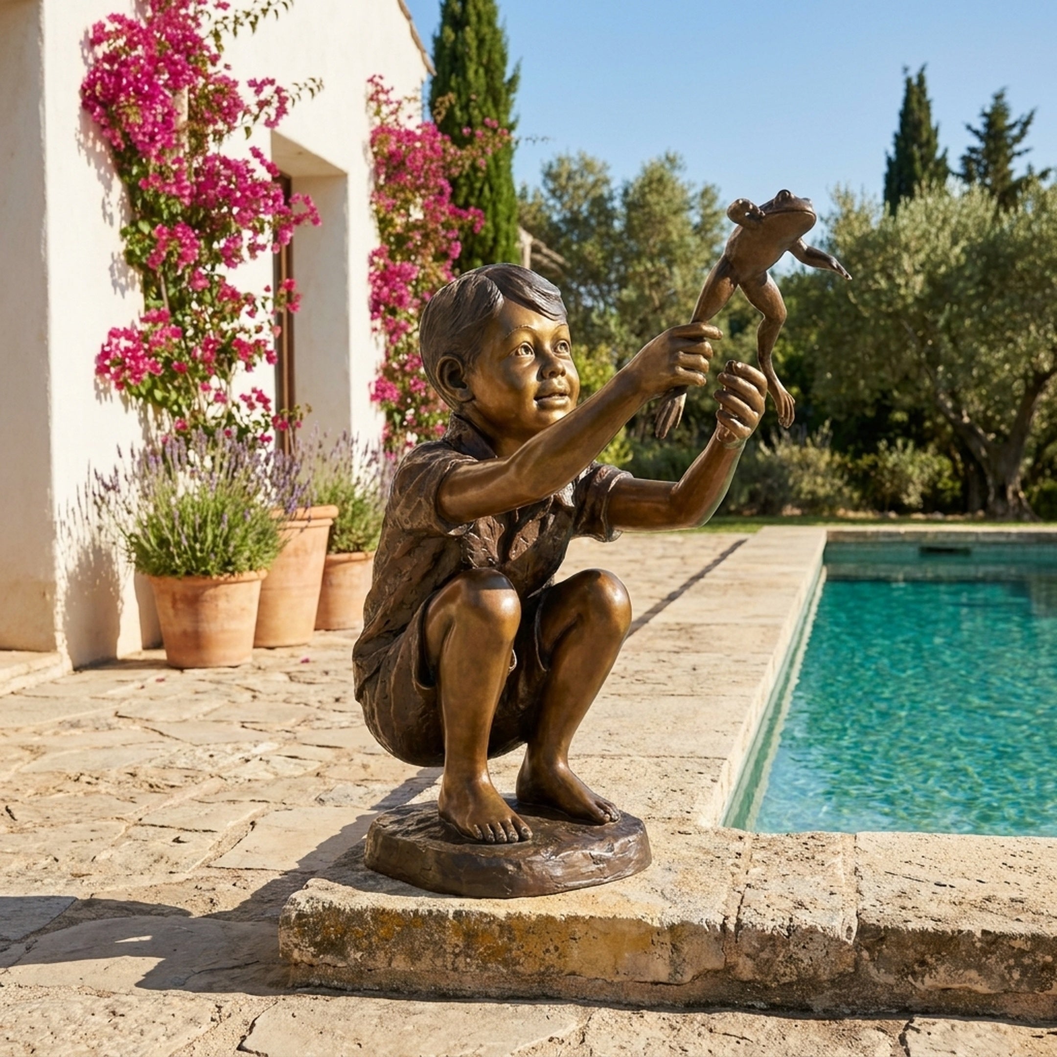 Life-Size Boy with Jumping Frog Bronze Sculpture by Giant Sculptures, crouching with frog held aloft, displayed on a sunlit stone poolside terrace.