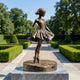 Life-Size Classical Ballerina Bronze Fountain by Giant Sculptures, 160cm dancer en pointe with pleated tutu on a rocky base, set in a manicured hedge garden.