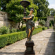 Life-Size Classical Goddess Lamp Bearer Bronze Sculpture by Giant Sculptures, 240cm verdigris figure holding a torch lamp, on a plinth along a garden path.