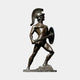 Life-Size Classical Greek Warrior Bronze Statue by Giant Sculptures in dark brown patina, shown in wide combat stance with sword, aspis shield, and plumed Corinthian helmet.