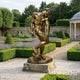 Life-Size Classical Male Figure Bronze Sculpture by Giant Sculptures, 220cm nude male in contrapposto pose on a stone plinth in a lavender garden.