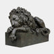 Life-Size Classical Recumbent Lion Bronze Sculpture by Giant Sculptures, shown in side view with head resting on crossed forepaws atop a rectangular plinth.