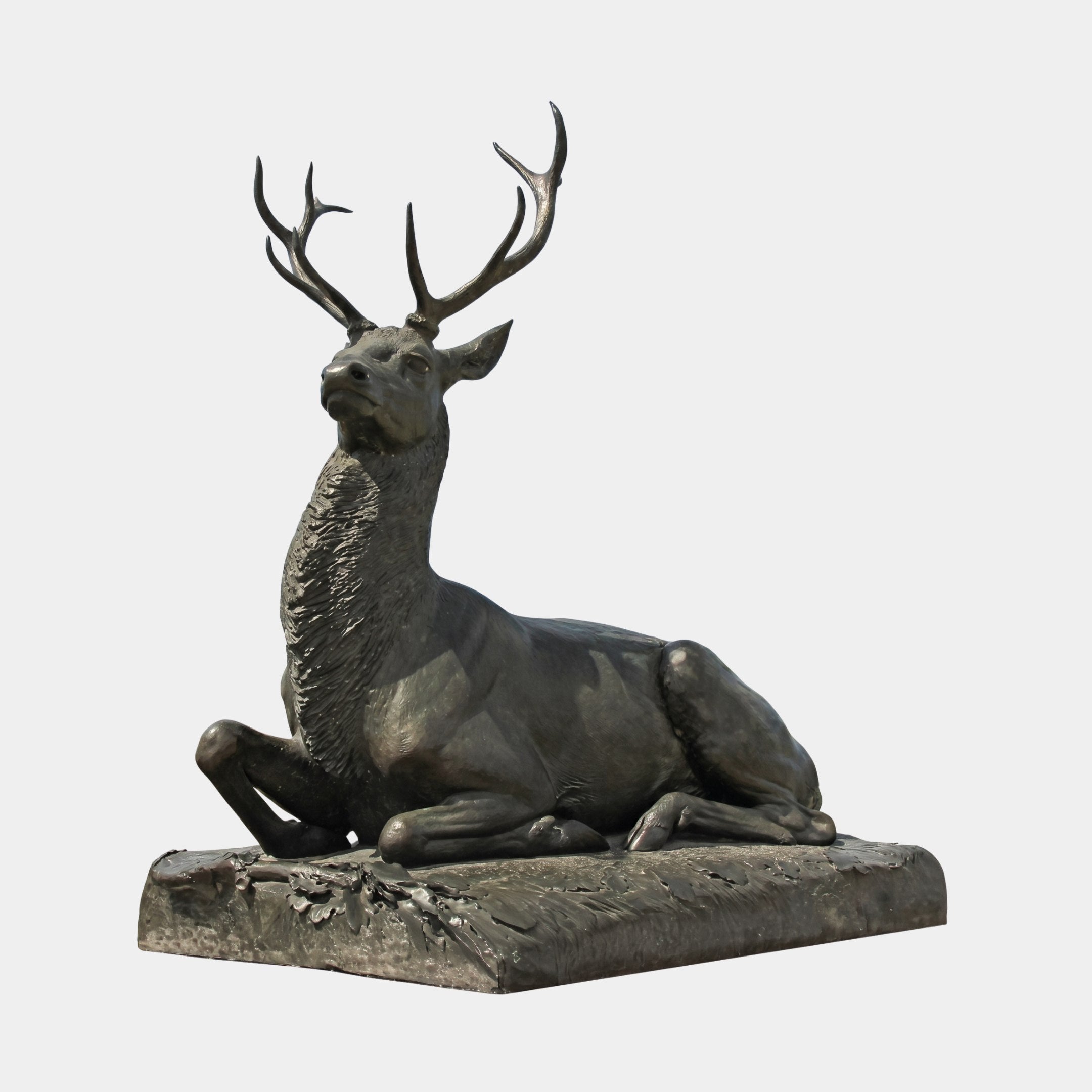 Life-Size Classical Recumbent Stag Bronze Sculpture by Giant Sculptures, shown in side view with antlers raised and legs tucked, in dark patina on a plain background.