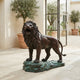 Giant Sculptures Life-Size Classical Roaring Male Lion Bronze Sculpture on a verdigris rocky base, displayed in a Mediterranean courtyard with olive trees.