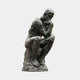 Life-Size Classical Seated Male Figure Bronze Sculpture by Giant Sculptures, 190cm, shown seated on a rocky base with chin resting on hand, dark verdigris patina.