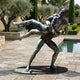 Life-Size Classical Wrestlers Bronze Sculpture by Giant Sculptures, two nude male figures locked mid-throw with verdigris patina, displayed on a poolside terrace.