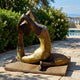 Giant Sculptures Life-Size Contemporary Backbend Figure Bronze Sculpture on a wooden base, displayed on a stone terrace beside greenery and a pool.
