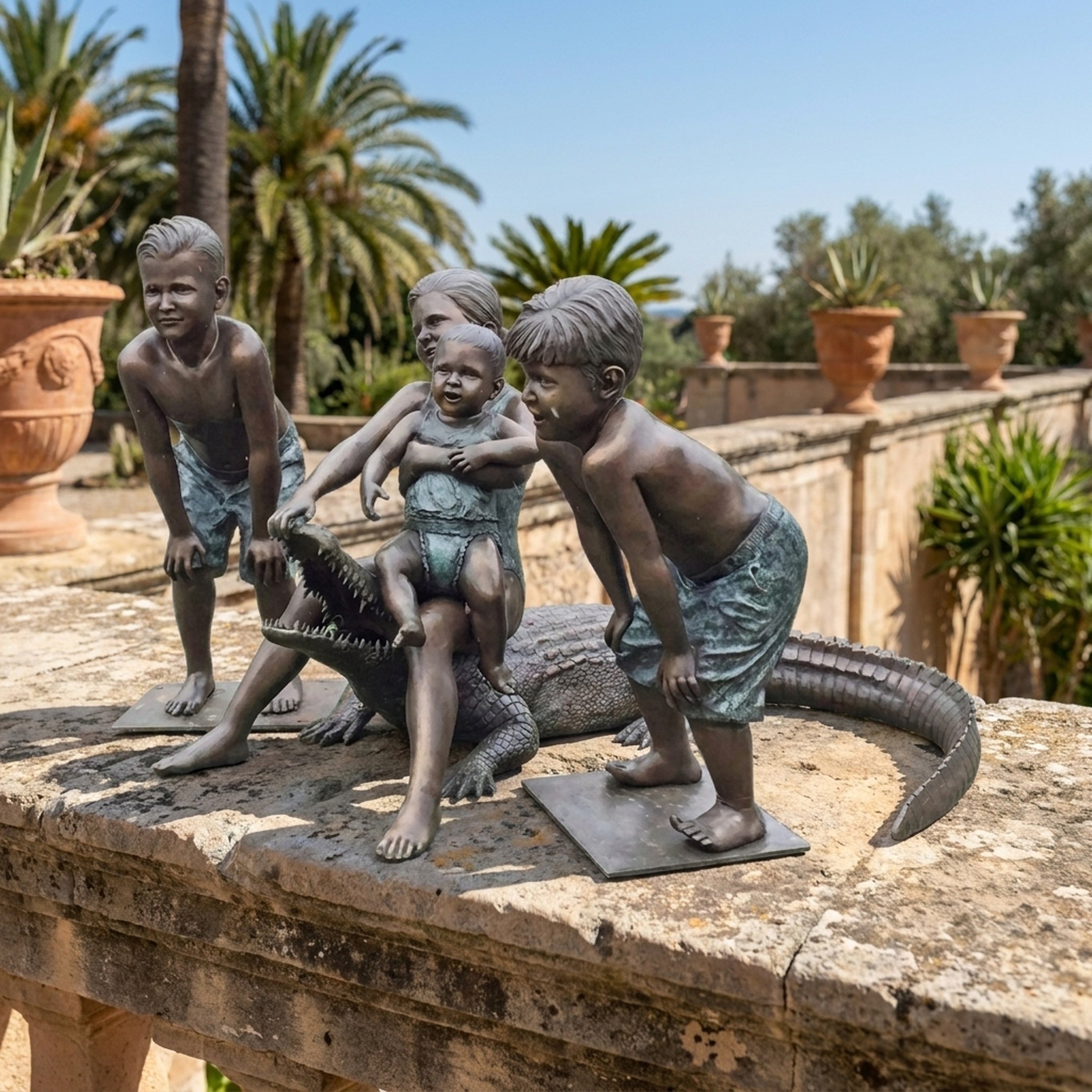 Life-Size Contemporary Children and Crocodile Bronze Sculpture by Giant Sculptures, four children playing with a crocodile, displayed on a sunlit stone terrace.