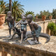 Life-Size Contemporary Children and Crocodile Bronze Sculpture by Giant Sculptures, four children playing with a crocodile, displayed on a sunlit stone terrace.