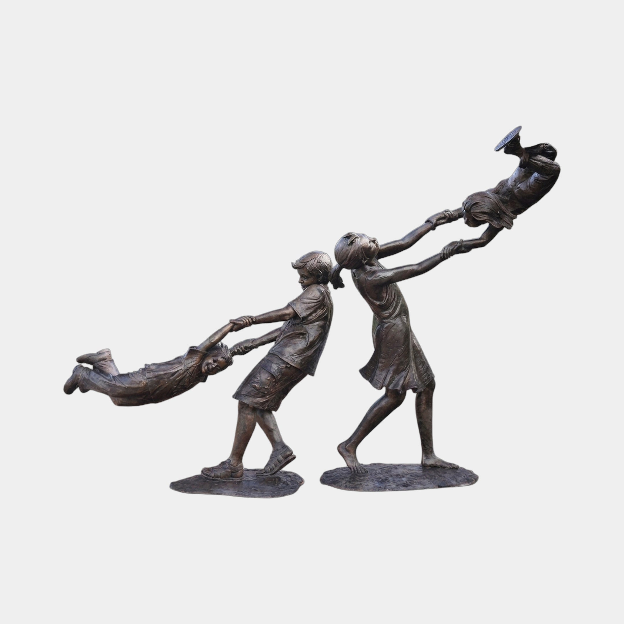 Life-Size Contemporary Children Playing Bronze Sculpture by Giant Sculptures, showing two standing children swinging a third horizontally between them, warm brown patina.