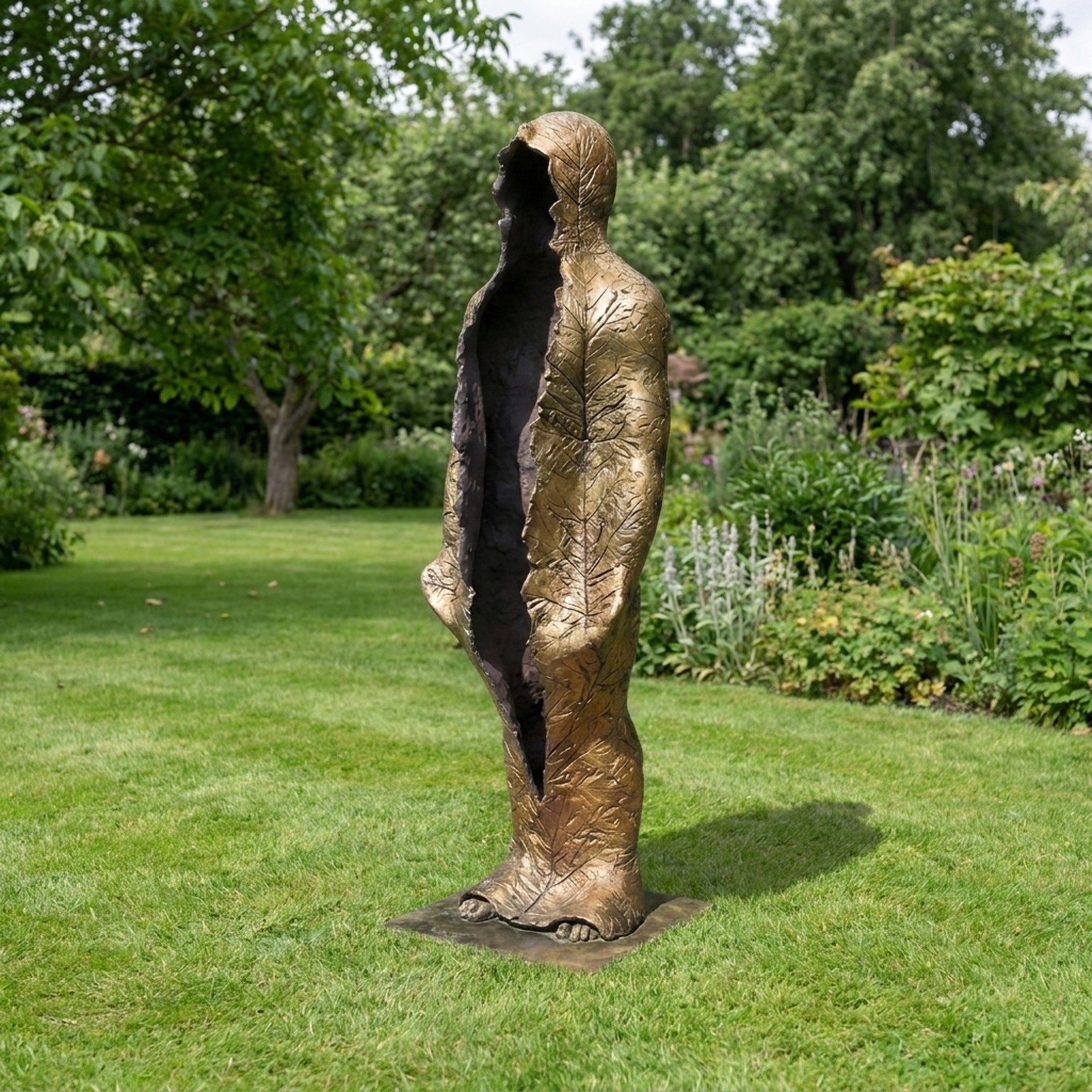 Life-Size Contemporary Emerging Figures Bronze Sculpture by Giant Sculptures, 210cm golden leaf-veined figure with split hollow interior, displayed on a garden lawn.