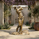 Life-Size Contemporary Female Golfer Bronze Sculpture by Giant Sculptures in follow-through swing pose, displayed on a stone patio beneath a wisteria-draped pergola.