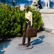 Life-Size Contemporary Fragmentary Traveller Bronze Sculpture by Giant Sculptures, suited man with briefcase and missing torso, displayed on a garden terrace.