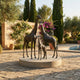 Life-Size Contemporary Giraffe Family Group Bronze Sculpture by Giant Sculptures on a circular base, displayed on a Mediterranean poolside terrace.