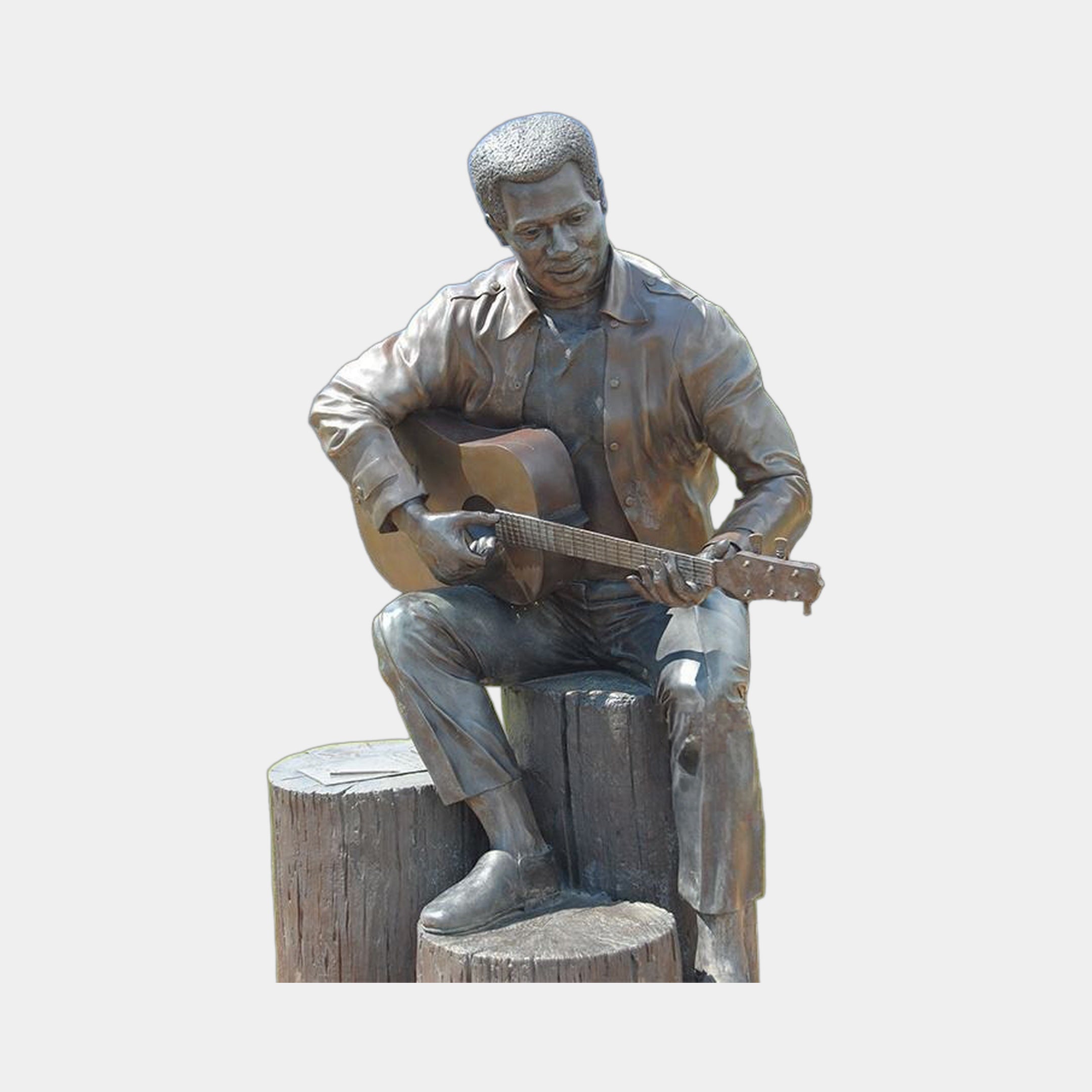 Life-Size Contemporary Guitarist Bronze Sculpture by Giant Sculptures, seated male figure on a bronze tree stump playing acoustic guitar with warm brown patina.