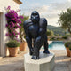 Life-Size Knuckle-Walking Gorilla Bronze Sculpture by Giant Sculptures on a stone plinth beside a poolside terrace with bougainvillea and olive trees.