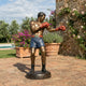 Life-Size Contemporary Male Boxer Bronze Sculpture by Giant Sculptures in fighting stance with red gloves and blue shorts, displayed on a sunlit garden terrace.