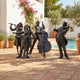 Life-Size Contemporary Musicians and Singing Children Bronze Sculpture by Giant Sculptures, six dark-patina figures performing on a terracotta poolside patio.