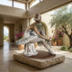 Life-Size Contemporary Seated Ballerina Bronze Sculpture by Giant Sculptures, white tutu and bronze skin patina, on stone plinth in a sunlit villa entrance.