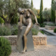 Life-Size Contemporary Seated Female Figure Bronze Sculpture by Giant Sculptures on a dark granite plinth in a Mediterranean garden with lavender and cypress.