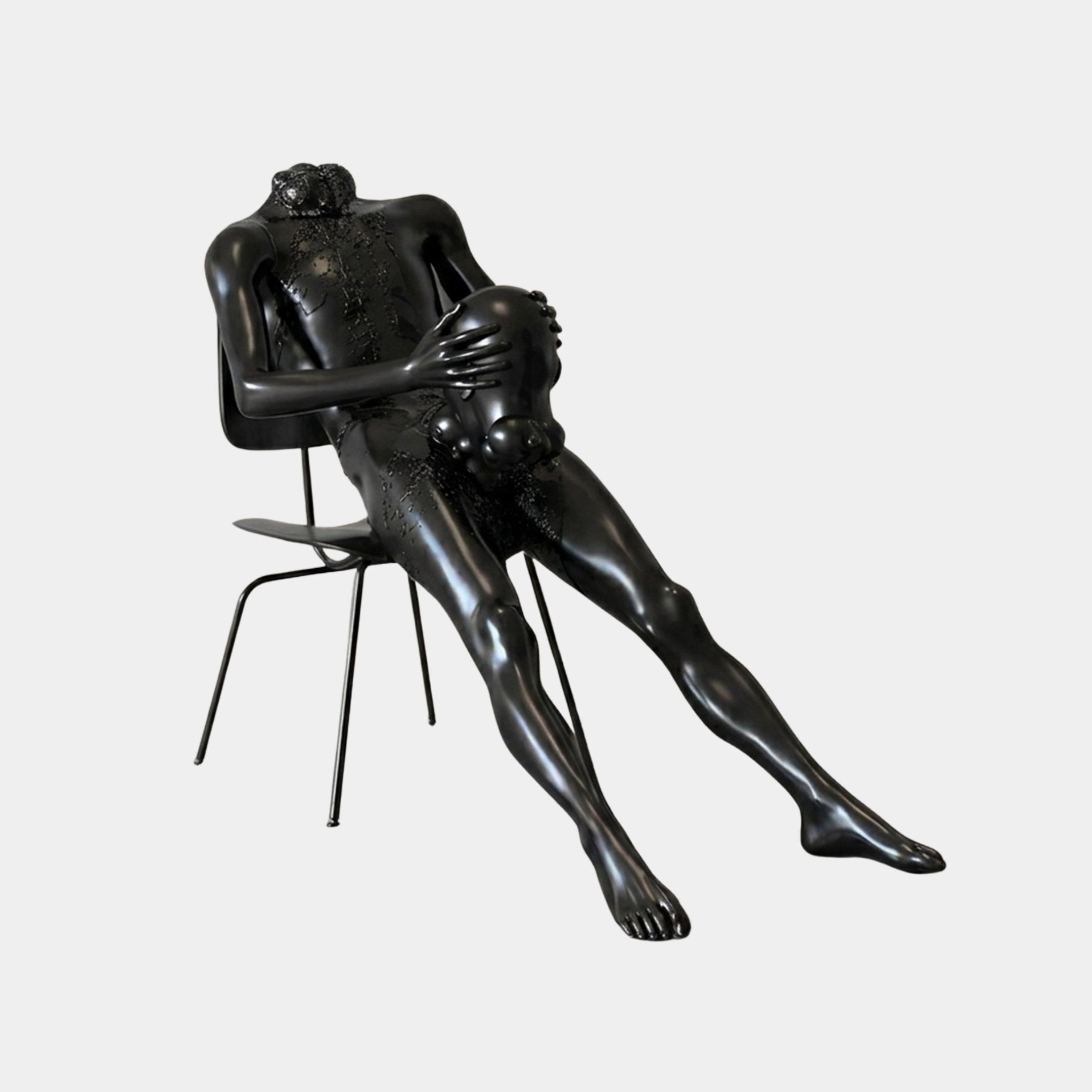 Life-Size Contemporary Seated Male Figure Bronze Sculpture by Giant Sculptures, 150cm matte black nude reclining on a slender metal chair with coral-like growths across torso and head, shown on a plain background.