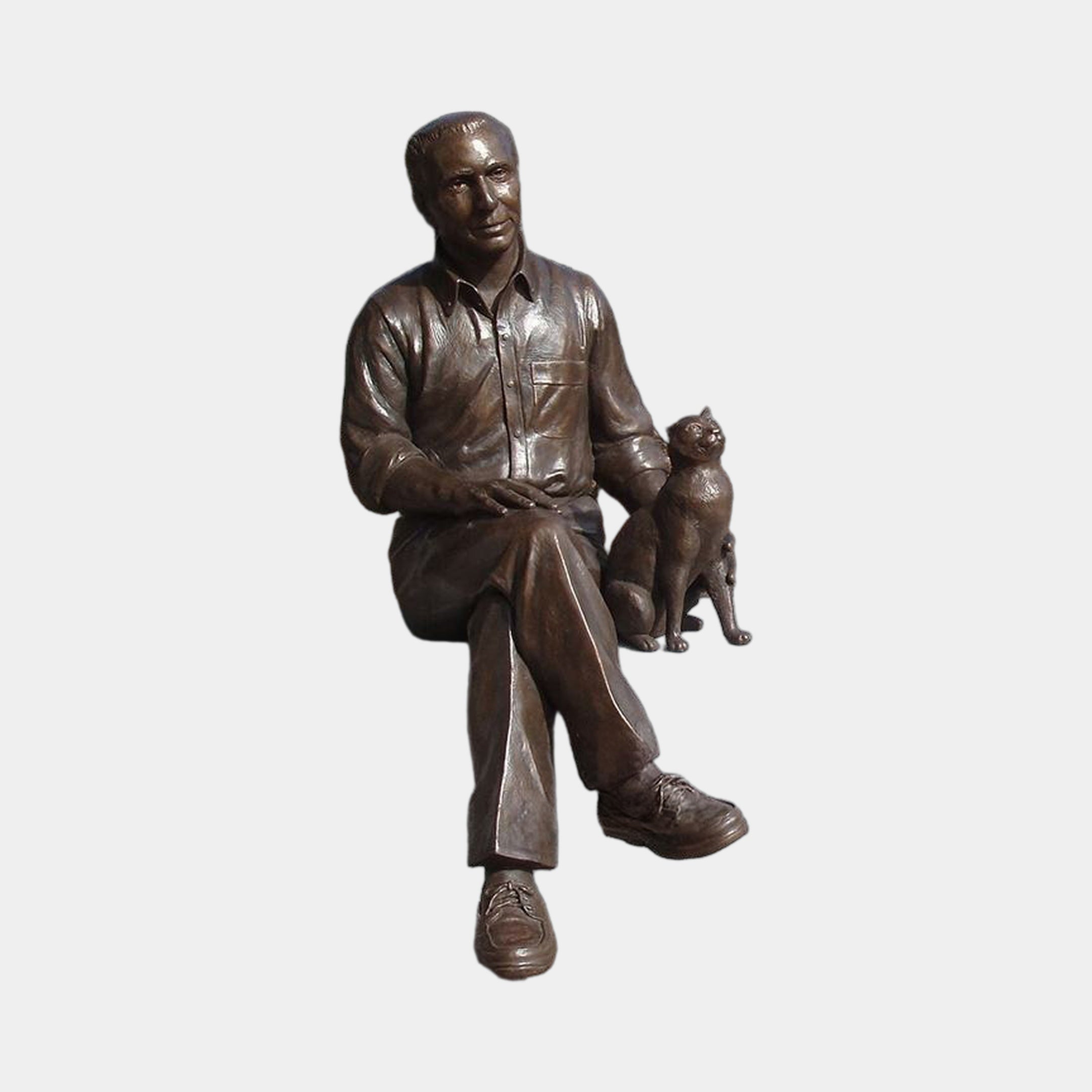 Life-Size Contemporary Seated Man and Cat Bronze Sculpture by Giant Sculptures, shown in warm brown patina with the figure seated beside an alert cat.