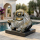 Life-Size Contemporary Seated Orangutan Bronze Sculpture by Giant Sculptures on a black stone base beside a poolside terrace with olive trees and bougainvillea.