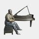 Life-Size Contemporary Seated Pianist and Grand Piano Bronze Sculpture by Giant Sculptures, smiling suited figure with golden-brown and black patina at the keys.
