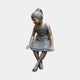 Life-Size Contemporary Sitting Girl Bronze Sculpture by Giant Sculptures, 130cm, shown seated with legs crossed and gaze lowered, against a plain grey background.