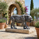 Life-Size Contemporary Stalking Tiger Bronze Sculpture by Giant Sculptures on a stone plinth in a Mediterranean courtyard with olive trees and roses.