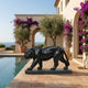 Life-Size Contemporary Walking Tiger Bronze Sculpture in polished black finish beside a Mediterranean villa pool with bougainvillea and sea view.