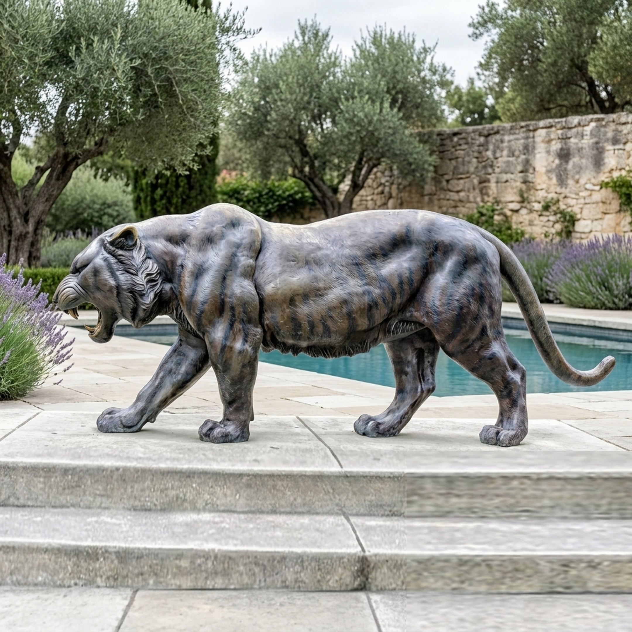 Life-Size Contemporary Walking Tiger Bronze Sculpture 220cm by Giant Sculptures, shown mid-snarl on stone paving beside a pool with lavender and olive trees.