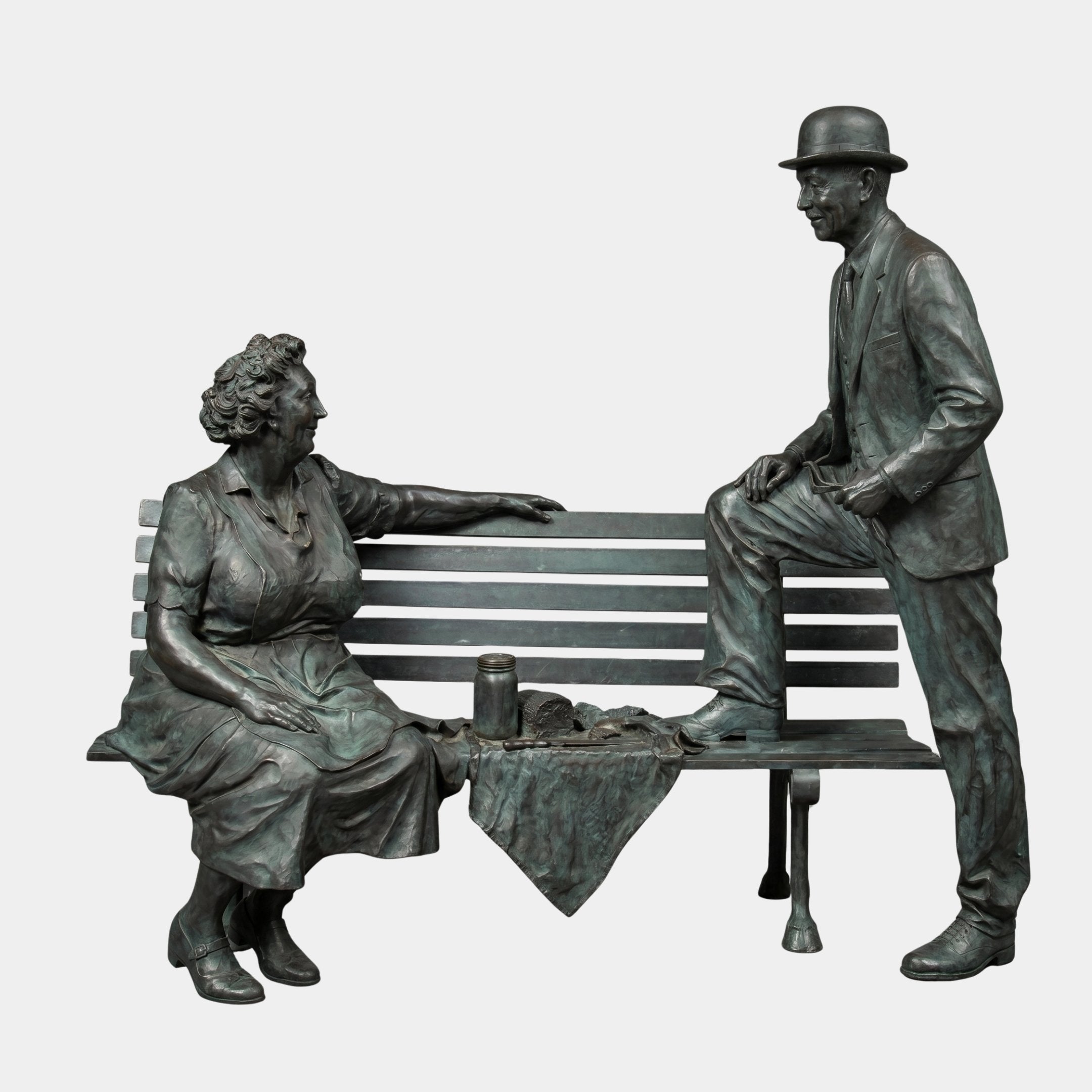 Giant Sculptures Life-Size Conversing Couple on Bench Bronze Sculpture 220cm, woman seated and bowler-hatted man leaning on bench, green-grey patina, plain background.
