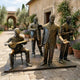 Life-Size Jazz Band Musician Figures Bronze Sculpture by Giant Sculptures, four performers with banjo, trombone, vocalist and clarinet, in a sunlit courtyard.