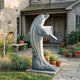 Life-Size Leaping Dolphin Bronze Sculpture with Mailbox by Giant Sculptures, 180cm grey-blue patina dolphin on a wave base at a stone cottage entrance.