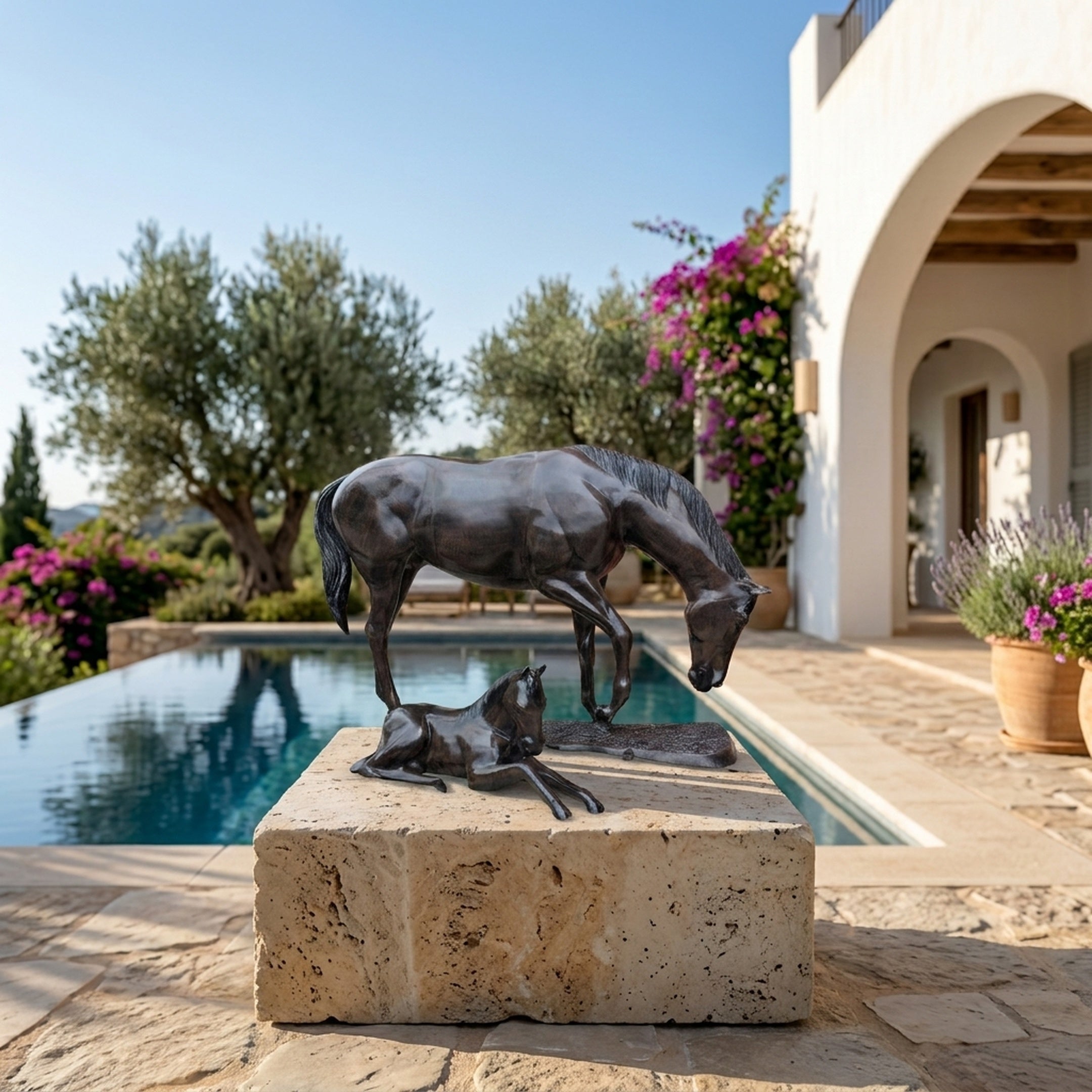 Life-Size Mare and Foal Bronze Sculpture by Giant Sculptures with dark patina, displayed on a travertine plinth beside a Mediterranean villa pool.