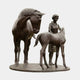 Giant Sculptures Life-Size Mare and Foal with Female Handler Bronze Sculpture in dark brown patina, showing the mare lowering her head toward the foal beside the woman.