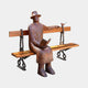 Life-Size Modern Seated Reader Bronze Sculpture by Giant Sculptures, a hatted figure with book and a small bird on the bench, shown on a plain background.