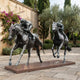 Life-Size Racing Horses and Jockeys Bronze Sculpture by Giant Sculptures, two galloping thoroughbreds with crouched riders on a granite base in a Mediterranean courtyard.