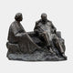Life-Size Seated Conversing Figures Bronze Sculpture by Giant Sculptures, 220cm, showing two adults on a rocky base with dark patina against a plain background.