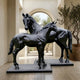 Life-Size Standing Mare and Foal Bronze Sculpture by Giant Sculptures, two black patina horses on rectangular plinths in a light stone hallway with arched window.