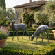 Life-Size Standing Stag and Grazing Doe Bronze Sculpture by Giant Sculptures on a lawn beside clipped hedges and lavender at a Tuscan stone villa.