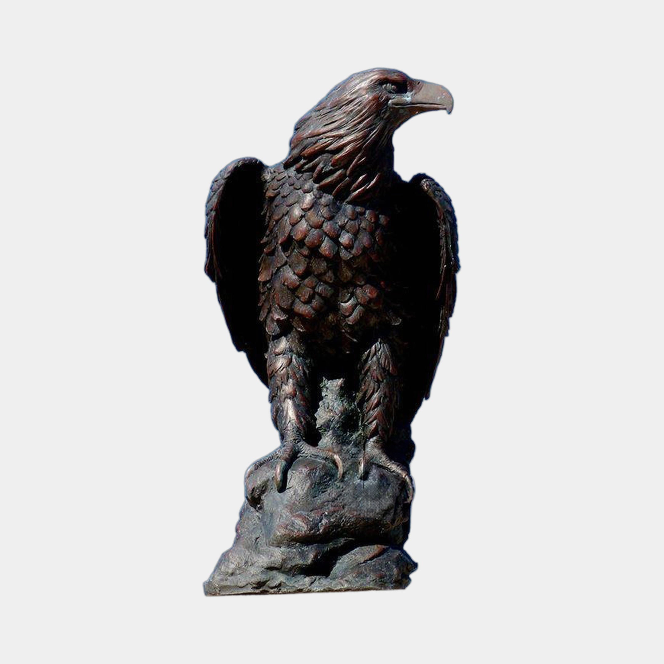 Life-Size Traditional Bald Eagle Bronze Sculpture from Giant Sculptures, perched on a rocky base with wings partially raised and a dark brown patina finish.